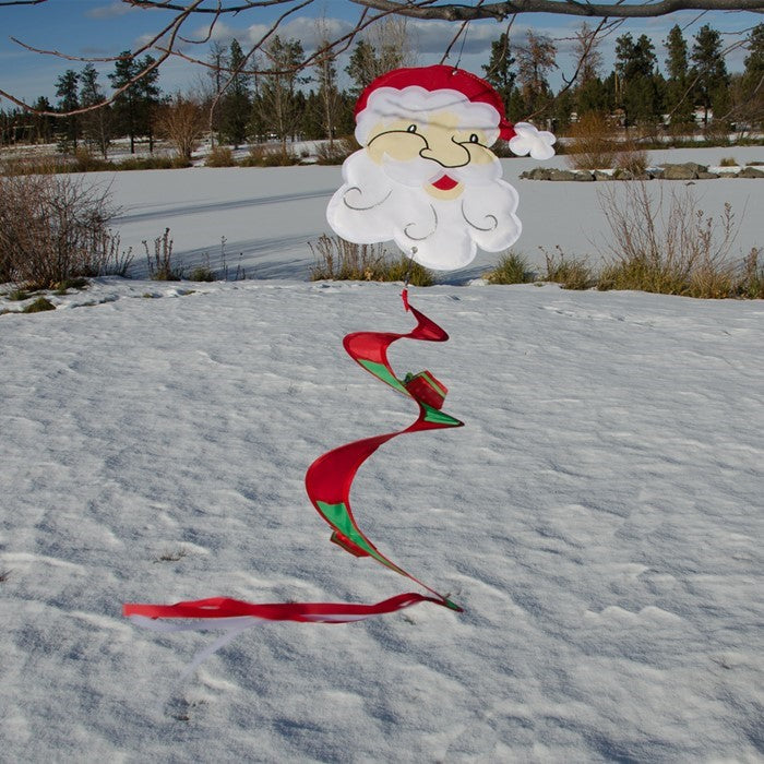 Santa Twister Tail decoration featuring a colorful Santa with twister tail and wrapped gifts, displayed outdoors in a festive setting.