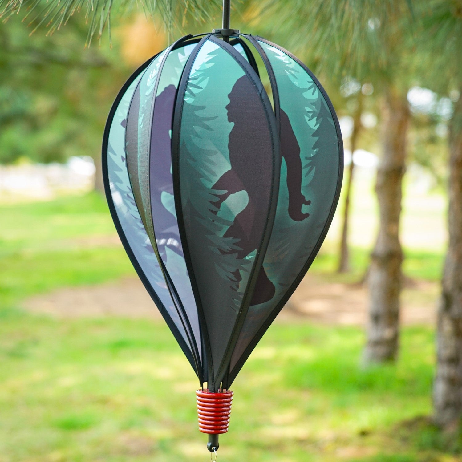 Sasquatch 6-Panel Hot Air Balloon spinner featuring colorful panels and streamers, elegantly displayed in an outdoor garden setting.