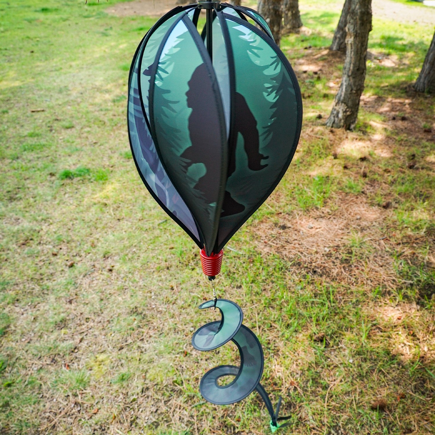 Sasquatch 6-Panel Hot Air Balloon spinner featuring colorful panels and streamers, elegantly displayed in an outdoor garden setting.