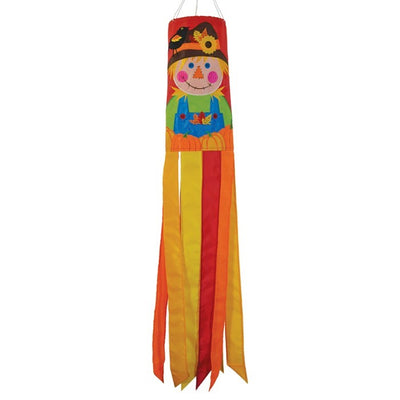 Scarecrow 40" Windsock displayed outdoors, featuring vibrant autumn colors and delightful scarecrow design with fluttering tails in a garden setting.