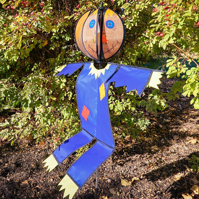 Colorful Scarecrow Ground Ball Spinner spinning in a garden setting, showcasing a friendly face with vibrant colors and durable design.