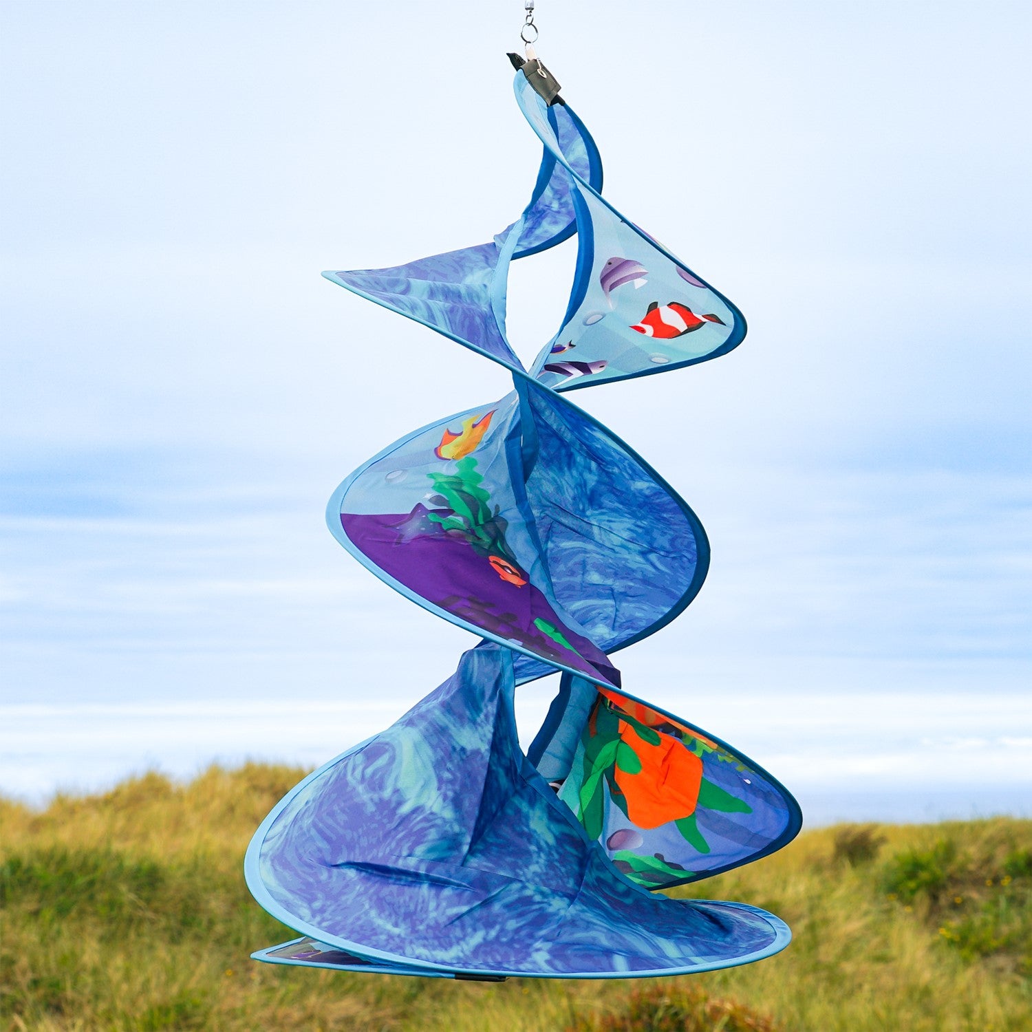 Sea Swimmers Spin Duet hanging garden decor featuring vibrant sea turtles spinning against a backdrop of ocean waves in an outdoor setting.