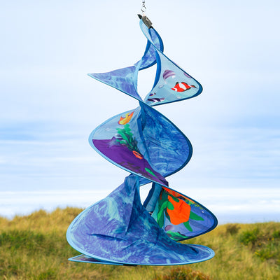 Sea Swimmers Spin Duet hanging garden decor featuring vibrant sea turtles spinning against a backdrop of ocean waves in an outdoor setting.