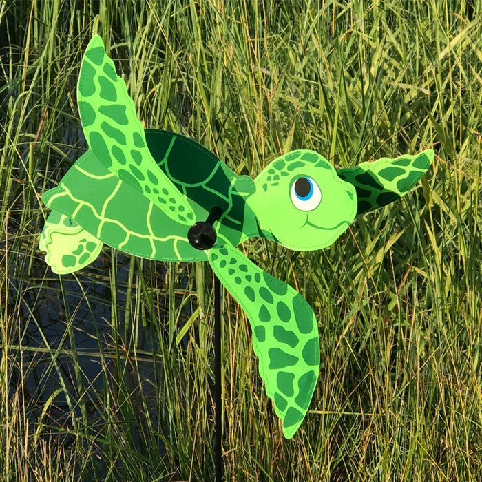 Sea Turtle Baby Whirligig in colorful design, featuring counter-rotating fins, displayed in a sunny garden setting, enhancing the outdoor atmosphere.
