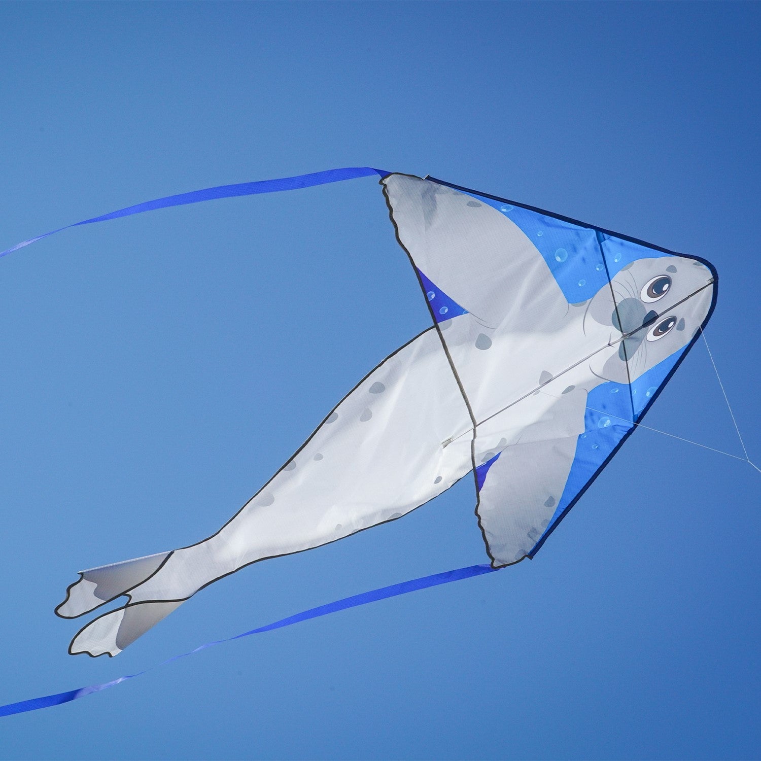 Seal 46 inch Fly-Hi Kite featuring a colorful sea life design soaring in the blue sky with streamer tails fluttering behind.
