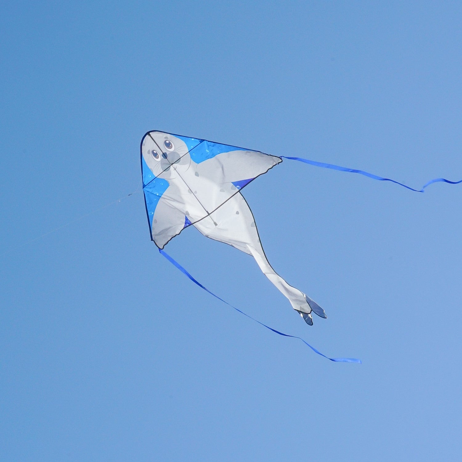 Seal 46 inch Fly-Hi Kite featuring a colorful sea life design soaring in the blue sky with streamer tails fluttering behind.