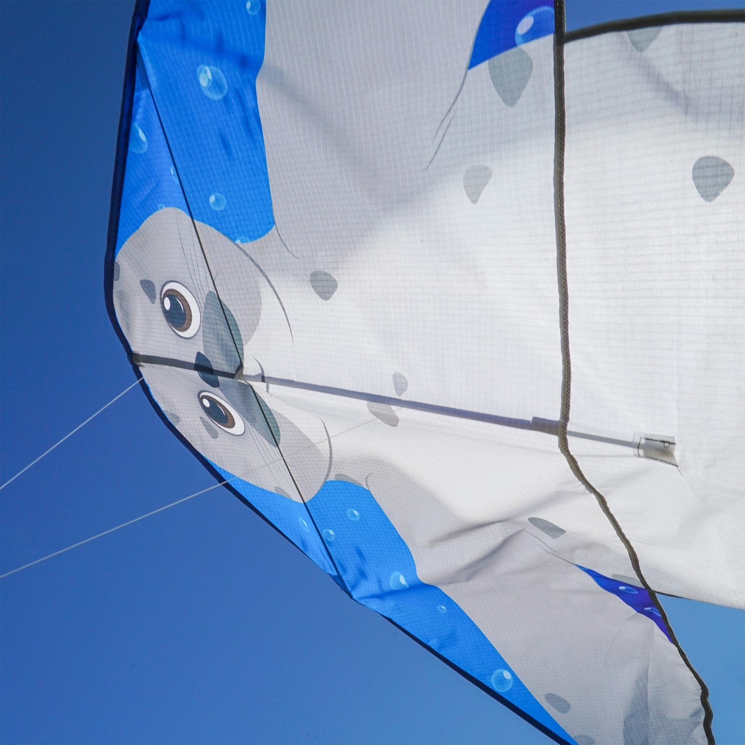 Seal 46 inch Fly-Hi Kite featuring a colorful sea life design soaring in the blue sky with streamer tails fluttering behind.