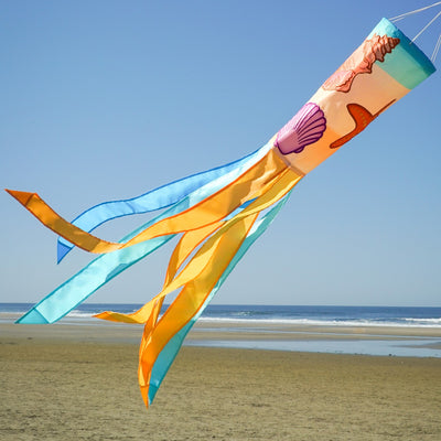Seashell 40-inch windsock featuring colorful applique designs and tails fluttering outdoors, adding a coastal charm to any garden space.