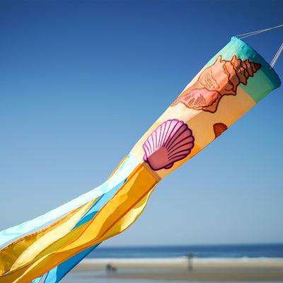 Seashell 40-inch windsock featuring colorful applique designs and tails fluttering outdoors, adding a coastal charm to any garden space.