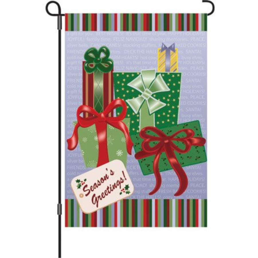 12 in. Season's Greetings garden flag featuring festive designs displayed outdoors, bringing holiday cheer to a garden setting.