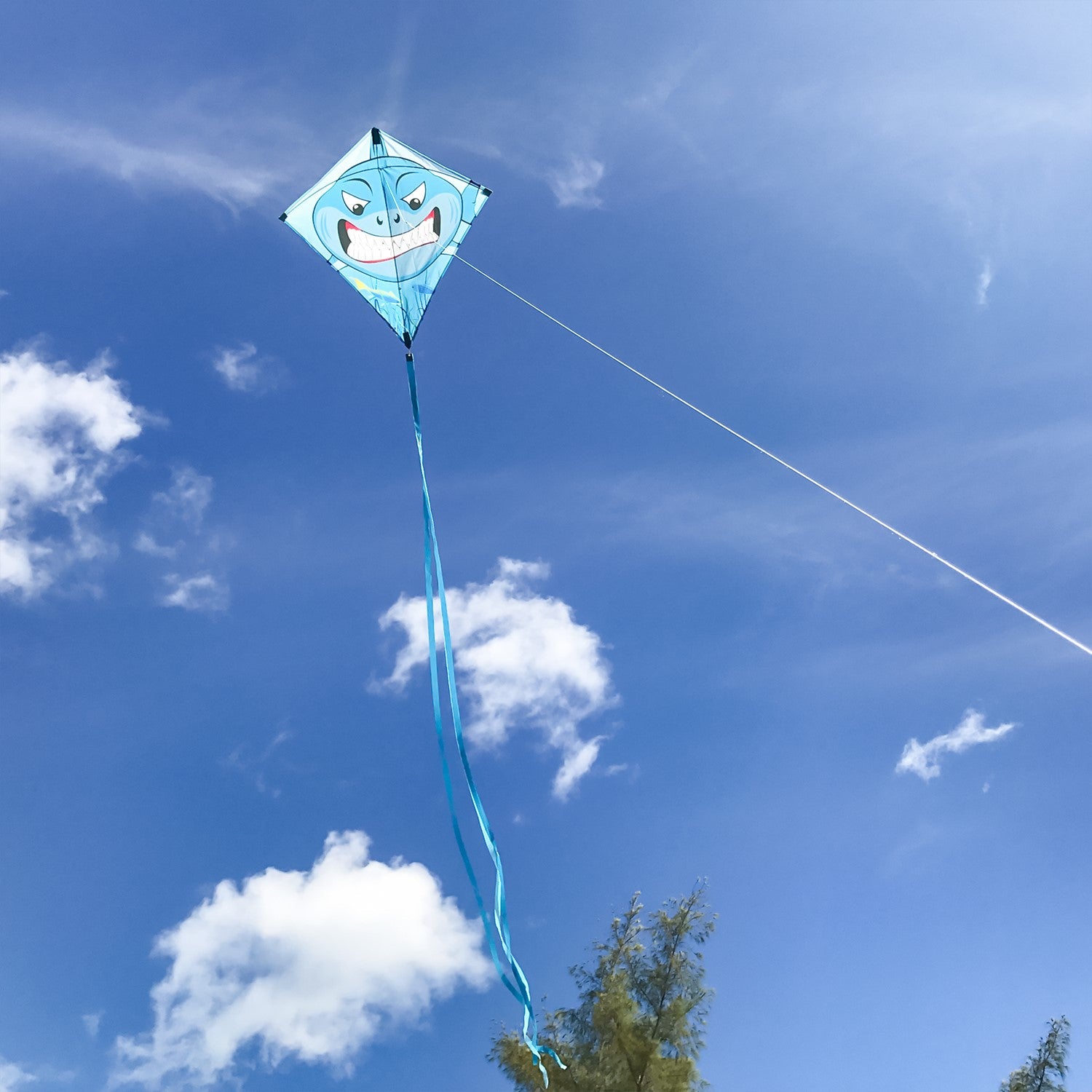 Shark 30" Diamond Kite with vibrant great white shark design flying high against a clear blue sky, showcasing its color-coordinated tails.