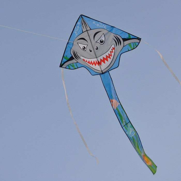 Shark Attack 45' Fly-Hi Kite featuring a Great White shark design soaring against a clear blue sky during a family outing in a park.