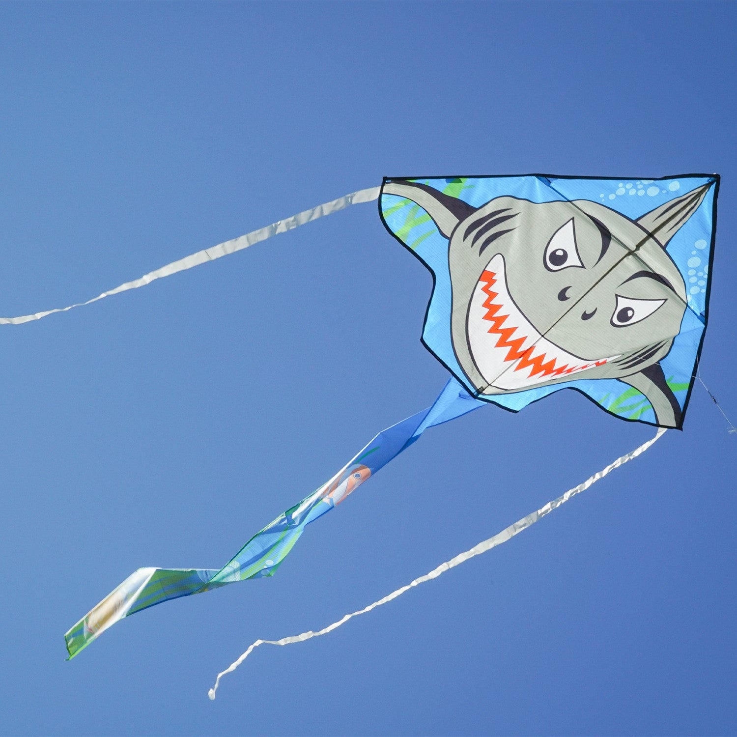 Shark Attack 45' Fly-Hi Kite featuring a Great White shark design soaring against a clear blue sky during a family outing in a park.