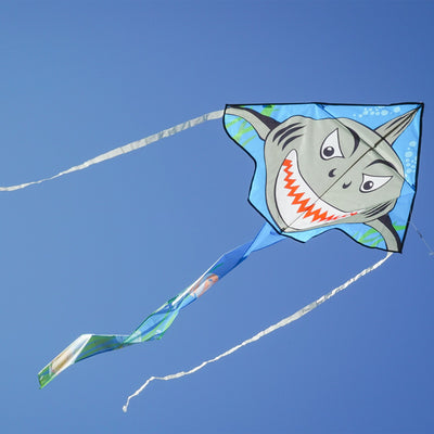 Shark Attack 45' Fly-Hi Kite featuring a Great White shark design soaring against a clear blue sky during a family outing in a park.
