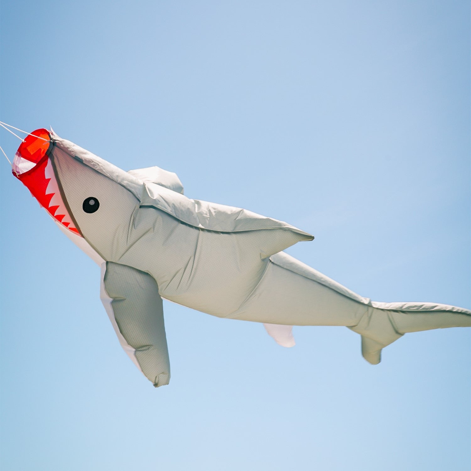 3D Shark Big Breeze WindsockTM in vibrant colors swaying in the breeze, designed for outdoor decoration and line laundry.