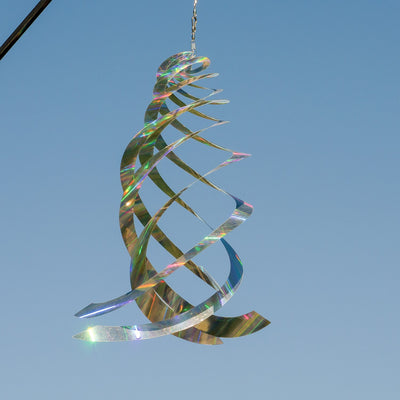 Sheen Crystal Spinner made of holographic Mylar, featuring five spinning blades reflecting rainbow colors, hanging in a garden with sunlight.