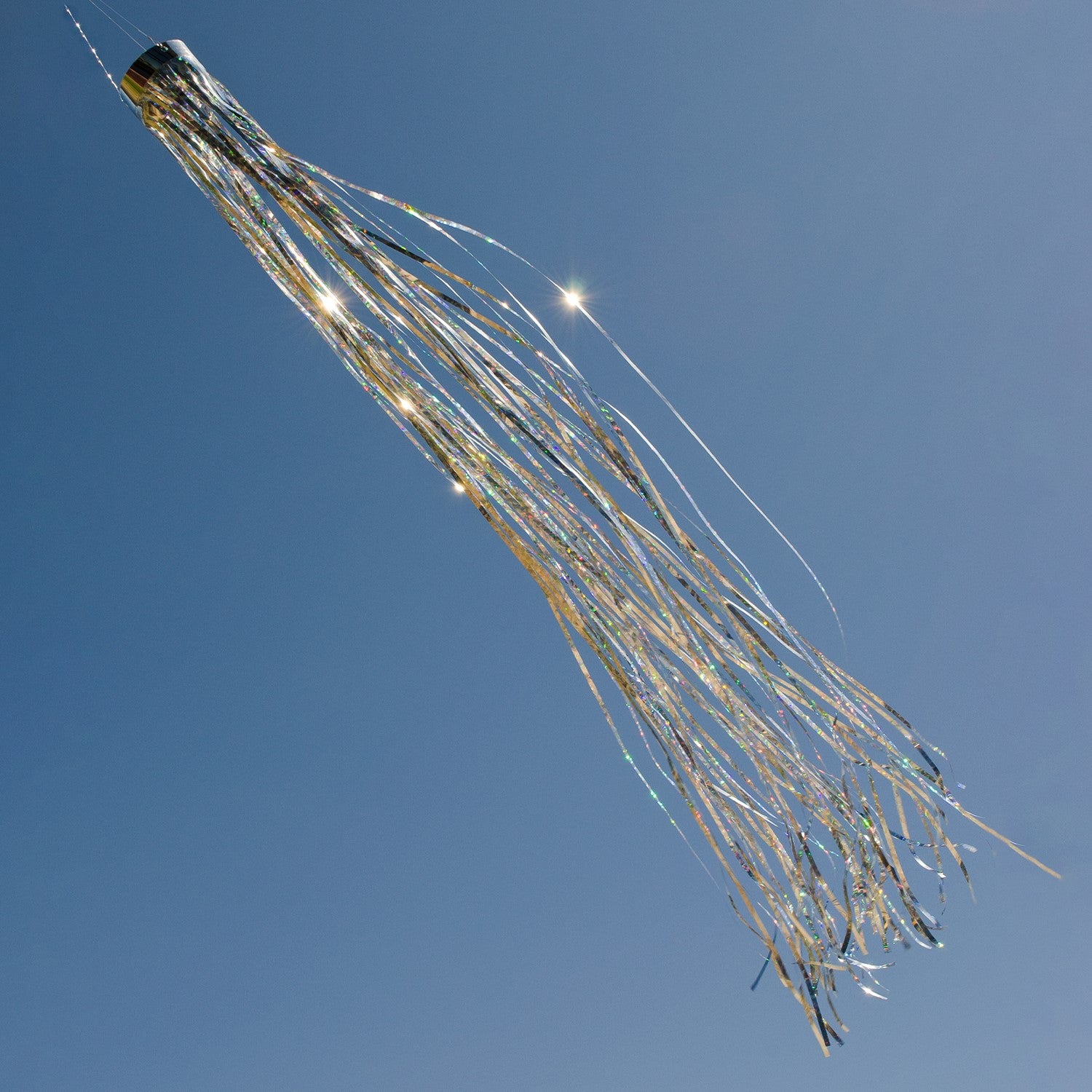Silver 51" Mylar windsock fluttering elegantly in a garden, showcasing its bright holographic design under the sunlight.