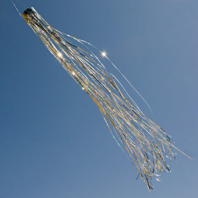 Silver 51" Mylar windsock fluttering elegantly in a garden, showcasing its bright holographic design under the sunlight.