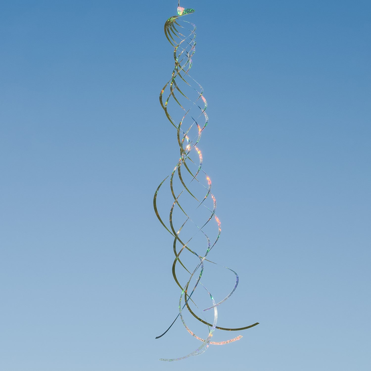 Silver Mylar Turbulence Spinner in a garden setting, showcasing its reflective surface and curlie design while spinning in the wind.