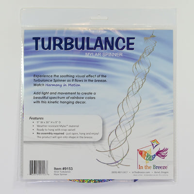 Silver Mylar Turbulence Spinner in a garden setting, showcasing its reflective surface and curlie design while spinning in the wind.
