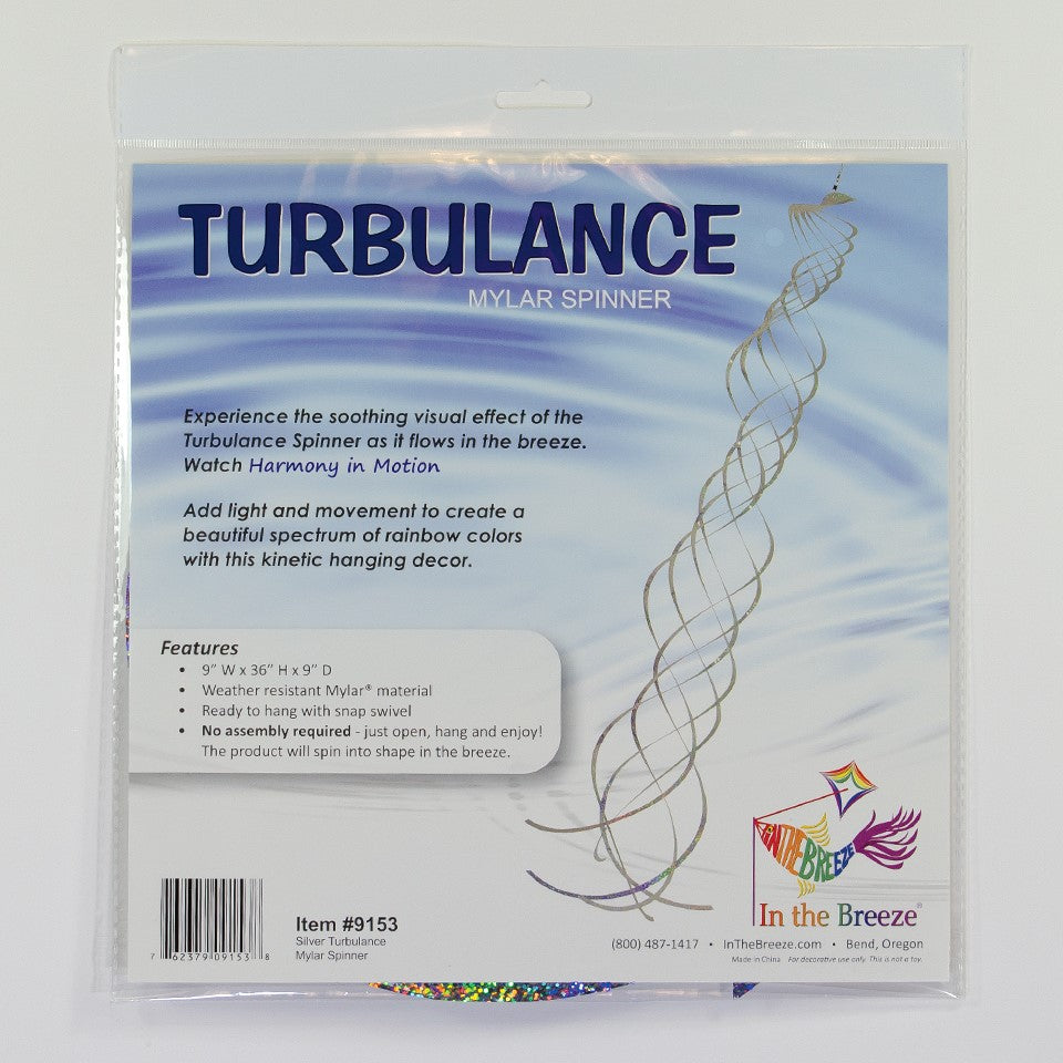 Silver Mylar Turbulence Spinner in a garden setting, showcasing its reflective surface and curlie design while spinning in the wind.