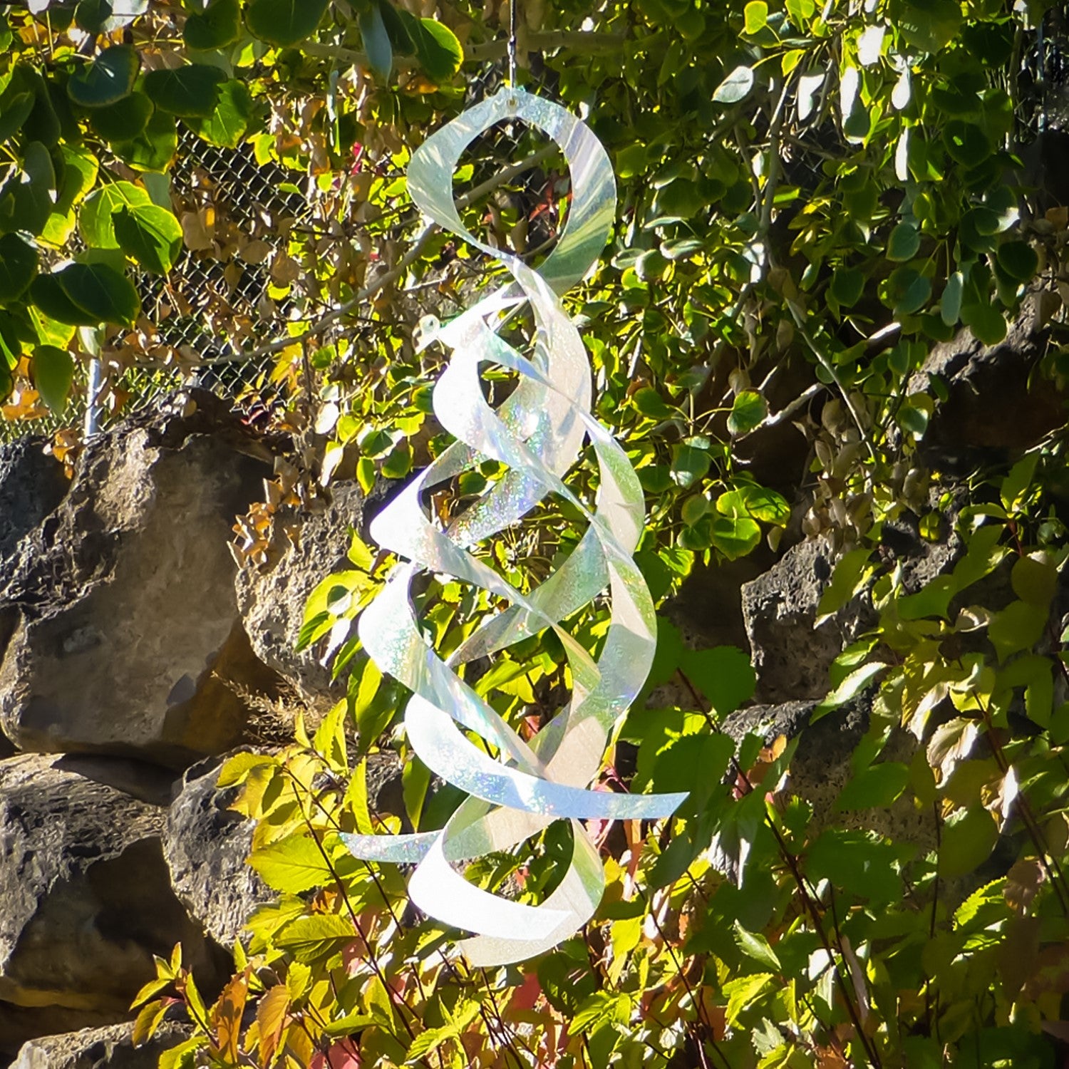 The Silver Sparkle Mylar Spin Quartet features a captivating design with shimmering silver curls, elegantly swaying in the breeze for stunning outdoor charm.