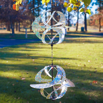 Silver Sparkle Vortex Double Spinner featuring interconnected Mylar spirals, elegantly spinning in an outdoor garden setting.
