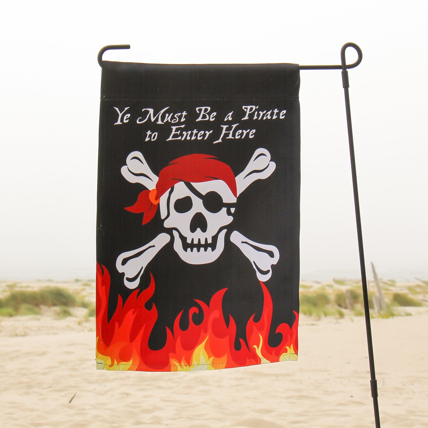 Skull 'n Flames double-sided garden flag featuring a bold skull design and fiery graphics, displayed outdoors on a flag pole.