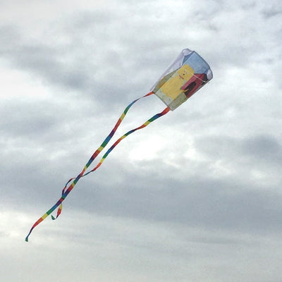 Sled Coloring Kite made of white ripstop fabric, featuring rainbow-striped tails, ready for personal decoration with crayons for an enjoyable outdoor experience.