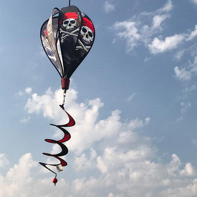 Smokin' Pirate Hot Air Balloon spinning in the breeze with a skull and crossbones design, adding vibrant decor to an outdoor garden setting.
