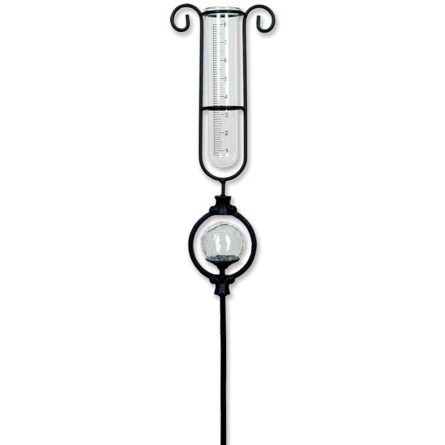 Solar rain gauge with decorative lights illuminating a garden at night, measuring rainfall with a clear tube, serving both function and aesthetic appeal.