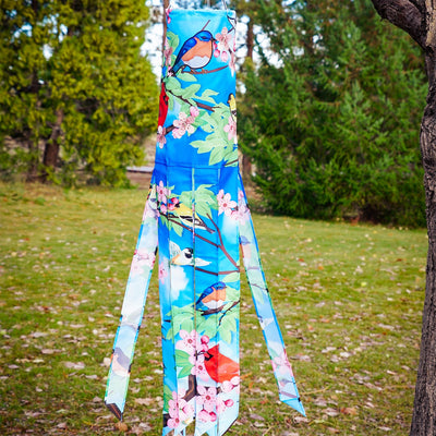 Songbird 40\" Illusion Windsock with colorful printed design and embroidered details, hanging freely in an outdoor garden setting.