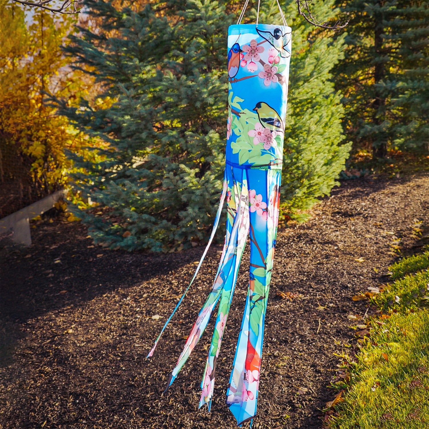 Songbird 40\" Illusion Windsock with colorful printed design and embroidered details, hanging freely in an outdoor garden setting.