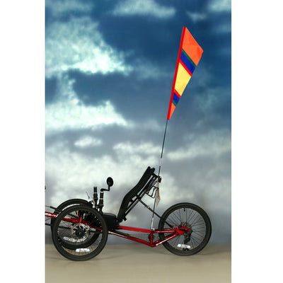 SoundWinds Fanion Recumbent Bike Flag in bright orange, measuring 9 inches by 33 inches, displayed on a recumbent bike with a fiberglass pole.
