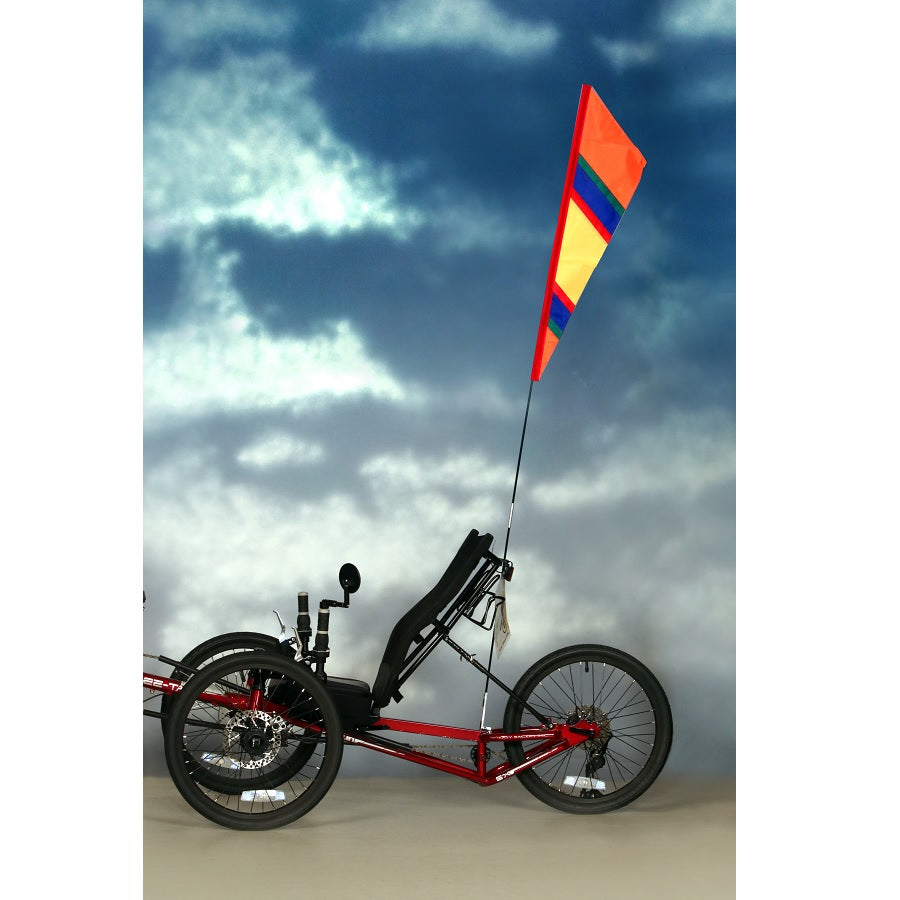 SoundWinds Fanion Recumbent Bike Flag in bright orange, measuring 9 inches by 33 inches, displayed on a recumbent bike with a fiberglass pole.