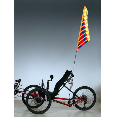 SoundWinds Sail Recumbent Bike Flag, bright yellow 9.5x35 inches, attached to a recumbent bike on an outdoor path.