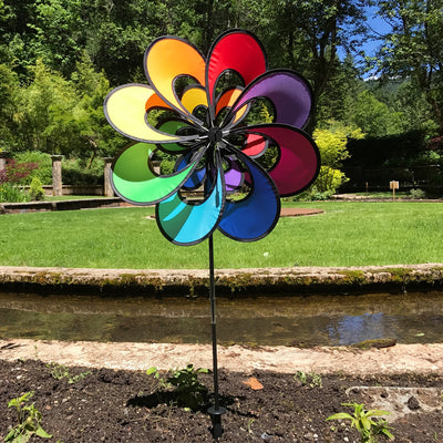 Spectrum Double Windee Wheelz rainbow petal spinner displayed in a garden, showing vibrant petals spinning joyfully in the breeze.