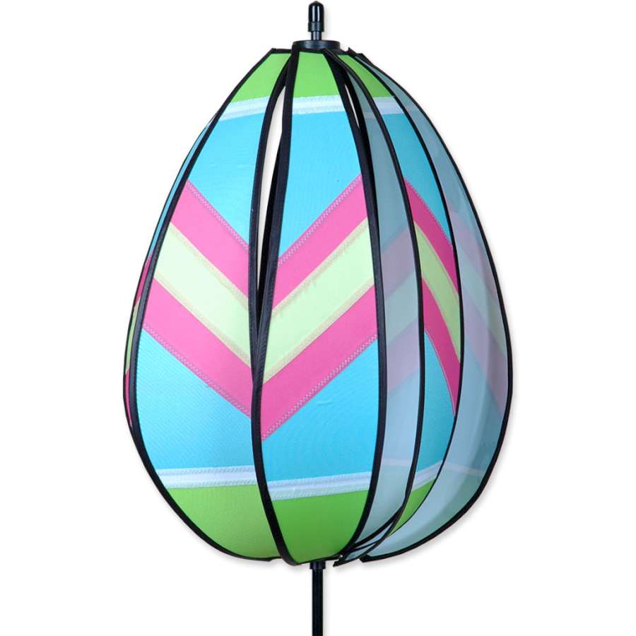 Spinning Egg Spinner in vibrant green and pink with traditional patterns, rotating in a sunny yard for an enchanting Easter display.