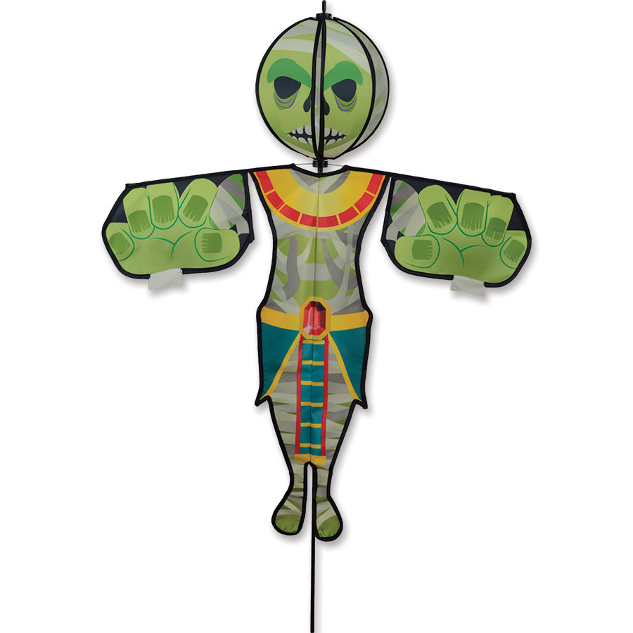 Spinning Friend - Mummy outdoor decoration featuring a whimsical spinning mummy head installed in a garden setting, swaying lightly in the breeze.