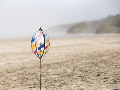 Spinning Lantern featuring six colorful weather-resistant panels spinning in the garden, standing tall at 41.5 inches with a pointed pole for easy ground insertion.