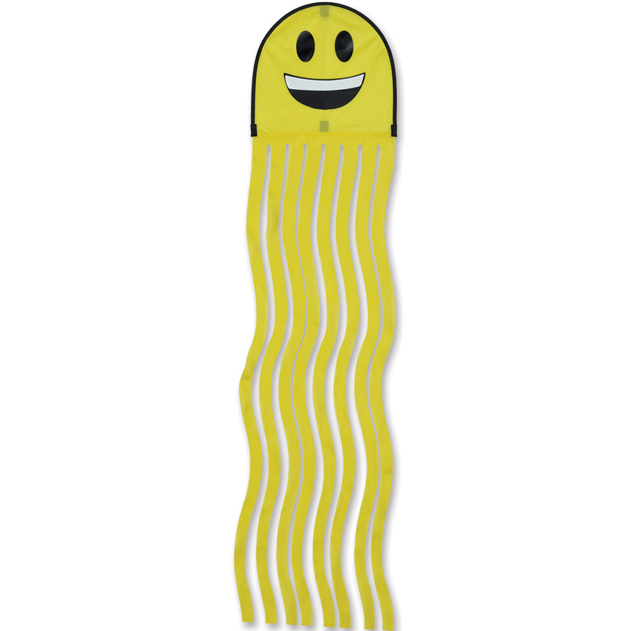 Squeaker Kite, an octopus-themed kite with vibrant colors and oversized eyes, flying against a blue sky with eight playful squiggly tails in motion.