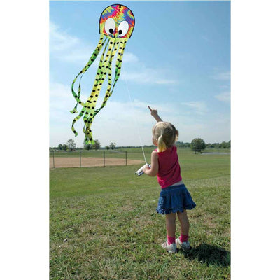 Colorful tie-dye Squeaky Kite shaped like an octopus soaring through the sky, measuring 20 x 80 inches, providing fun for families outdoors.