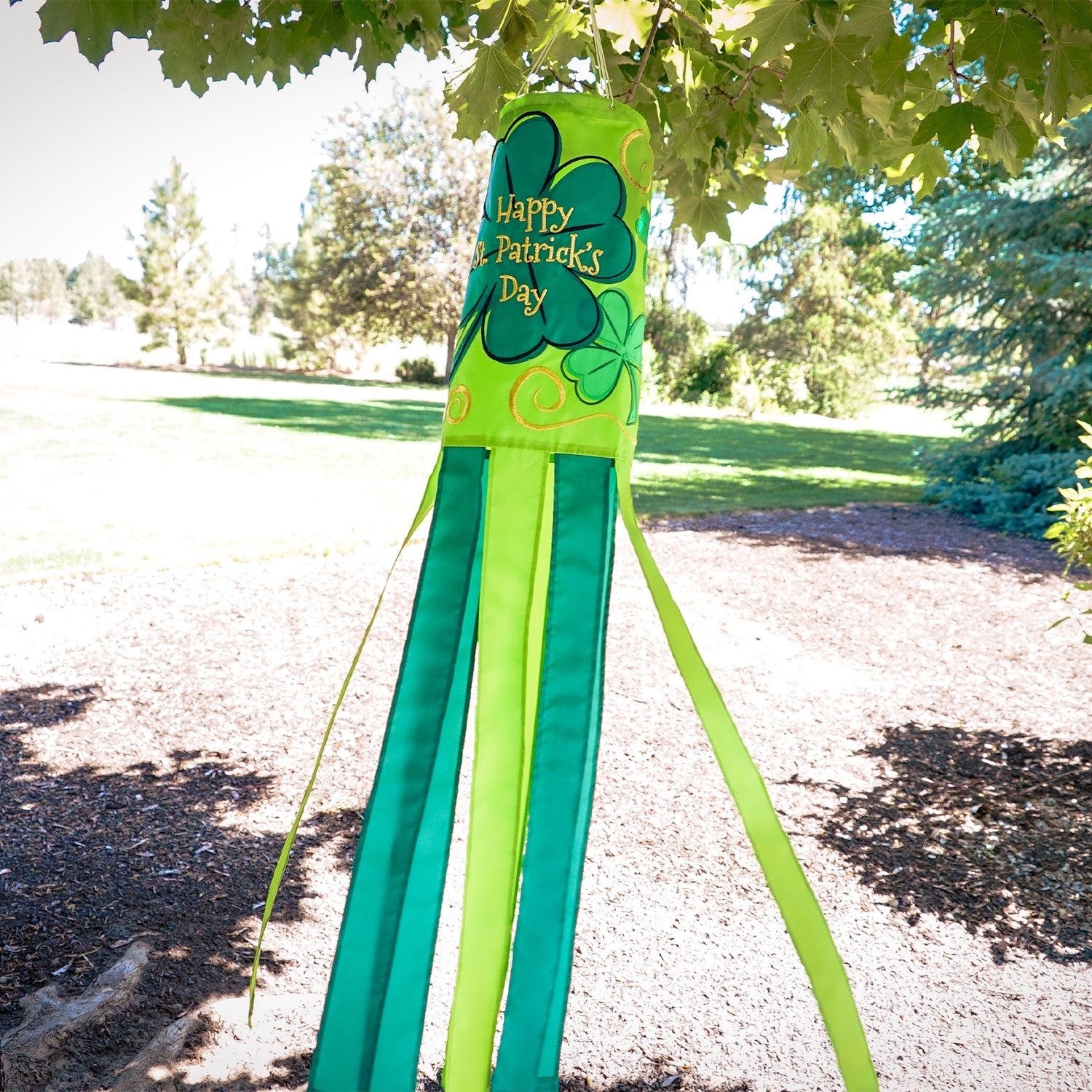 St Patrick's Day 40-inch windsock featuring vibrant four-leaf clover designs and color-coordinated tails, hanging outdoors in a garden.