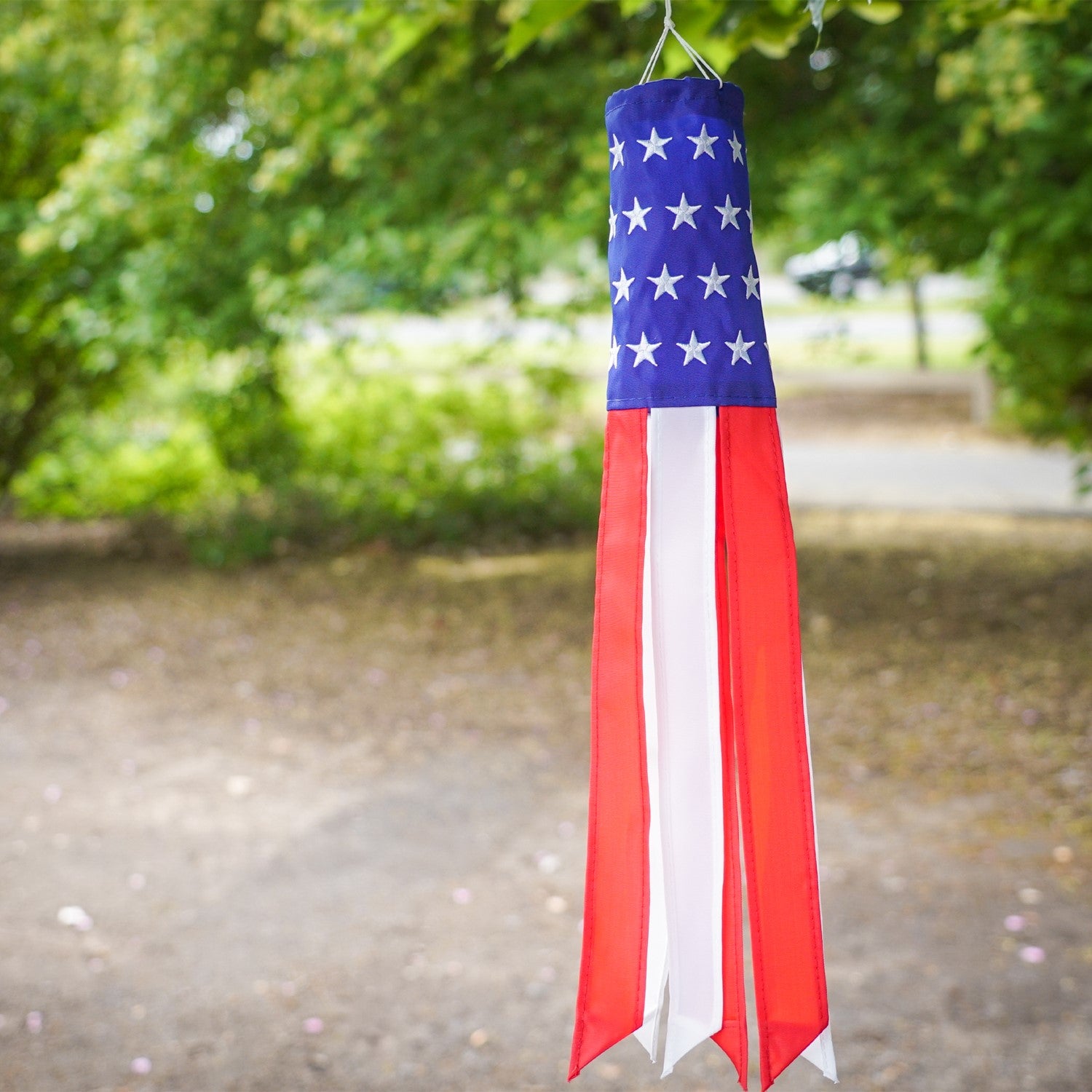 Brightly colored Stars & Stripes 18-inch windsock featuring USA flag design hanging outdoors, with vibrant tails fluttering in the breeze.