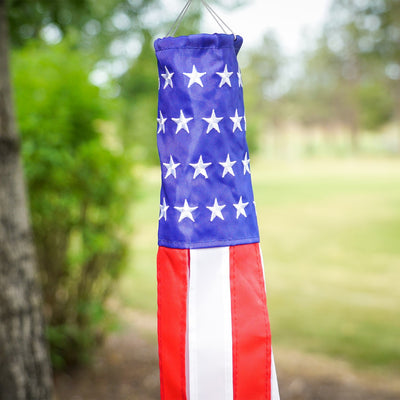 Brightly colored Stars & Stripes 18-inch windsock featuring USA flag design hanging outdoors, with vibrant tails fluttering in the breeze.