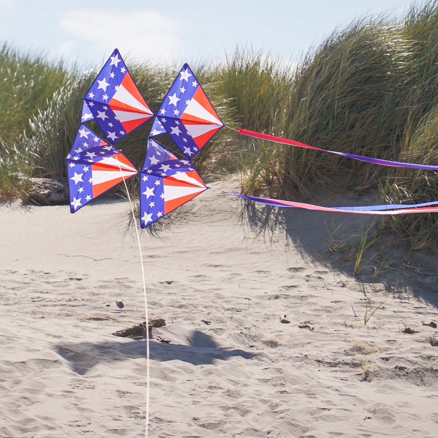 Stars & Stripes Tri-Kite soaring in the sky, featuring a vibrant red, white, and blue design, perfect for outdoor family activities.