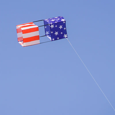 Stars & Stripes Double Box Kite soaring in a blue sky, showcasing vibrant red, white, and blue colors, designed for stability and fun.