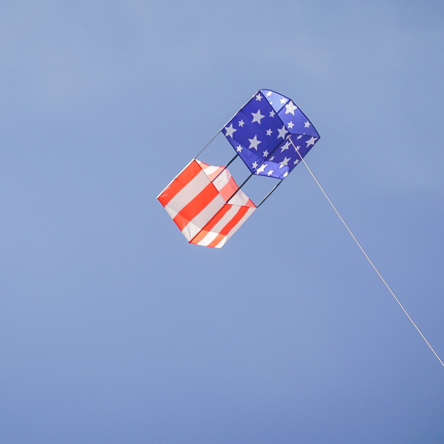 Stars & Stripes Double Box Kite soaring in a blue sky, showcasing vibrant red, white, and blue colors, designed for stability and fun.