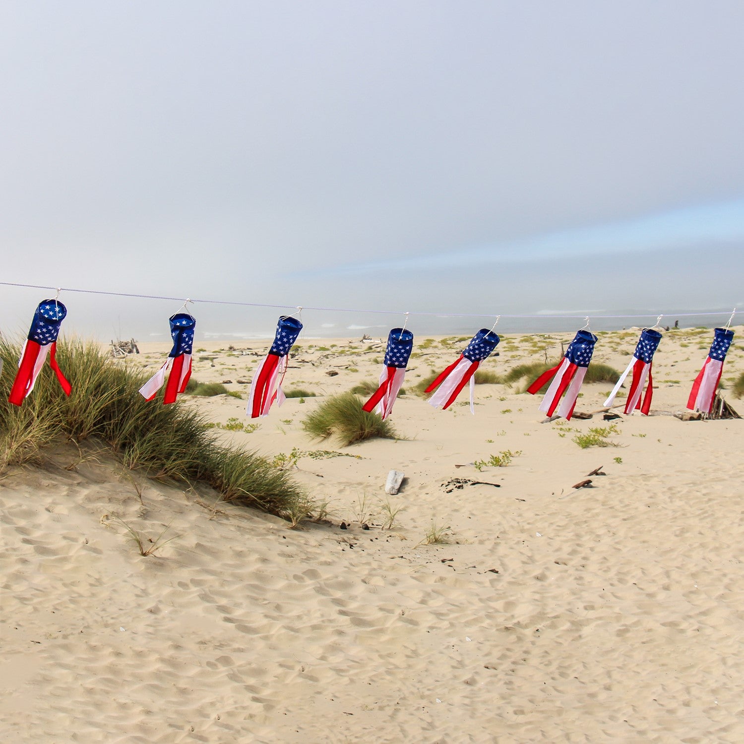 Stars & Stripes String of Babysocs featuring eight 12-inch windsocks swaying in the breeze, showcasing vibrant patriotic colors outdoors.
