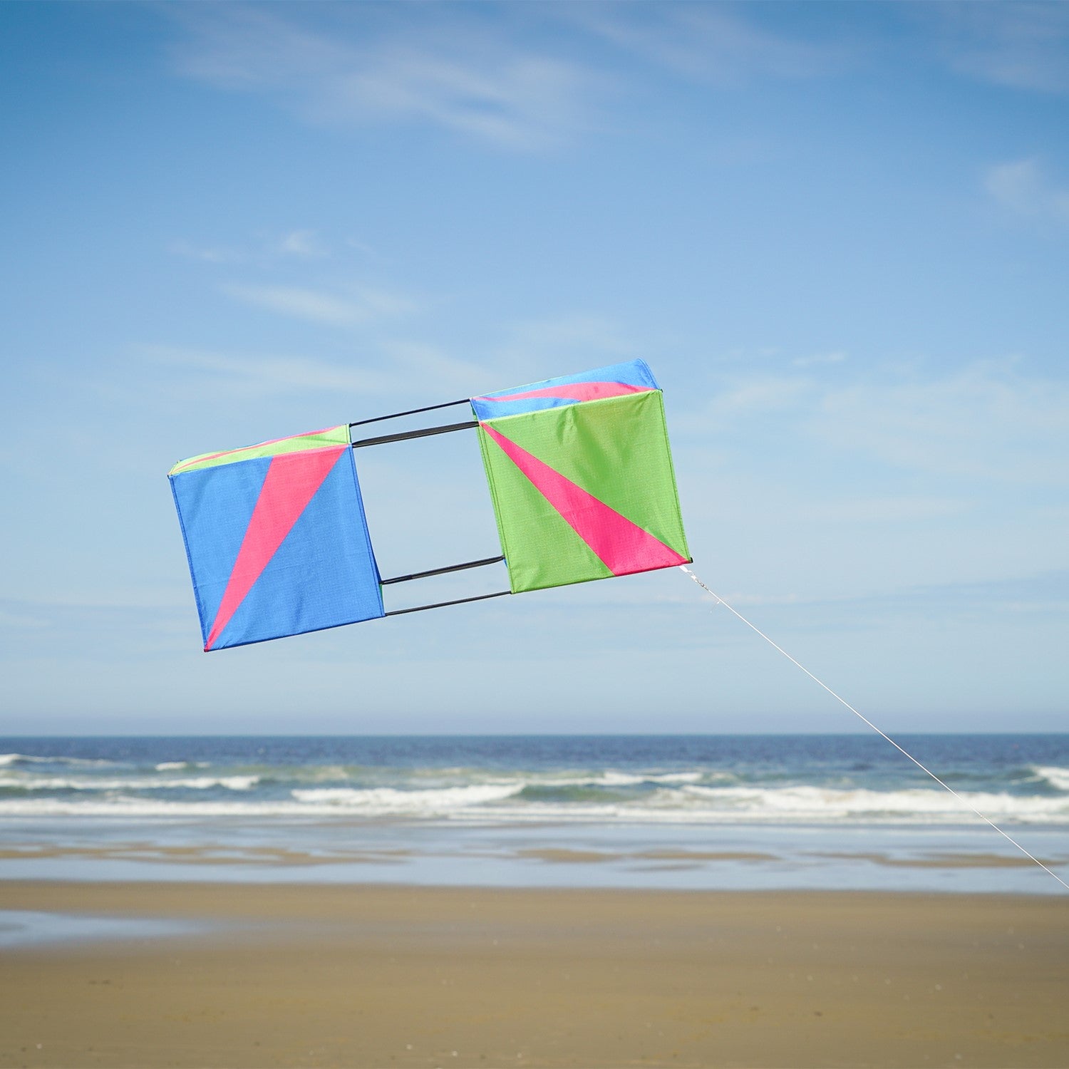 The Strike Double Box Kite soaring in the sky, showcasing its vibrant design and multiple sail surfaces for enhanced stability.